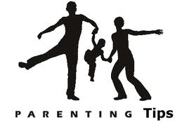 Parents with small child being swung between them playfully.