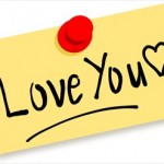 A piece of yellow paper with the words 'love you' and a heart written in black ink