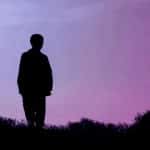a man standing in silhouette grieving
