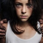 A teenager held by mans hands around her shoulders