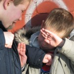 a child covers his face in fear of being bullied