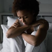 Depressed woman on bed.