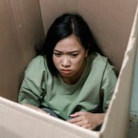 A woman gets anxious and trap herself in a box.