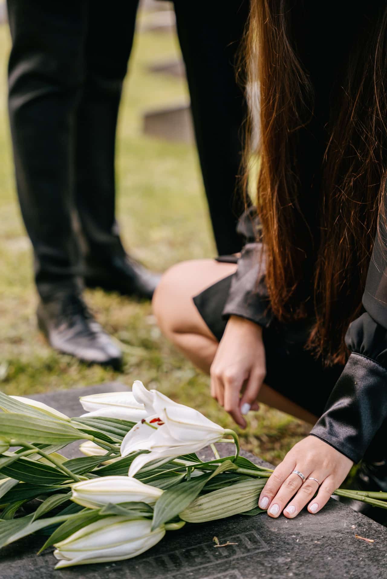 lily flowers are laid down on a grave in the grief of loved ones.