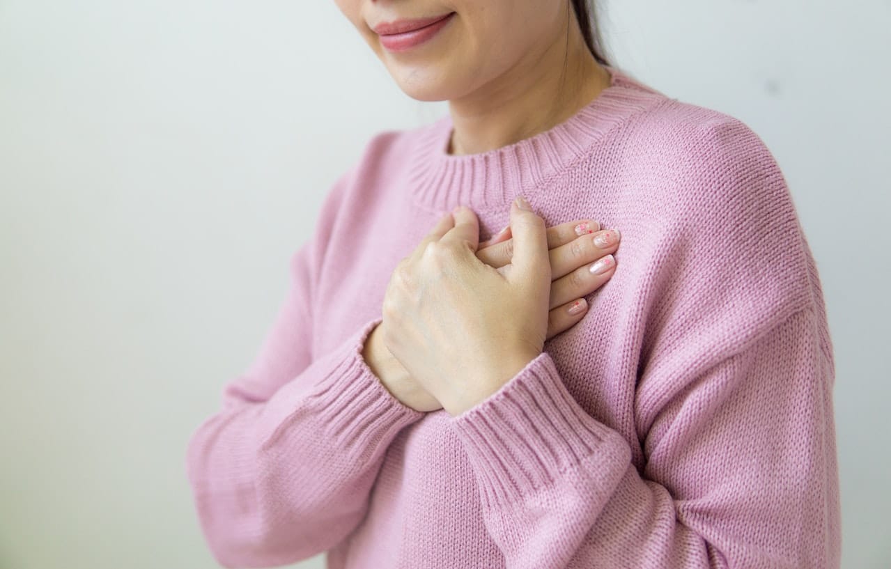 A woman touching her heart from the relief of historic sexual abuse.
