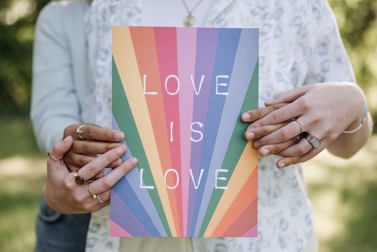 A sign of 'love is love' on rainbow background symbolise LGBTQ+ loves.